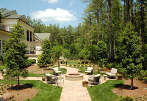 A hardscape including a firepit and chairs outside a building.