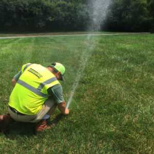A Bland team member checks a sprinkler to ensure the irrigation system is working properly